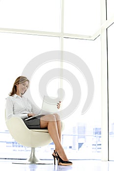 Businesswoman using laptop on knees