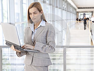 Businesswoman using laptop in office lobby