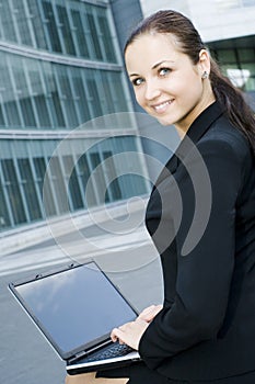 Businesswoman using laptop outside office