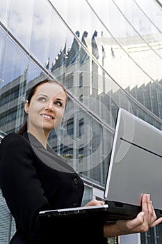 Businesswoman using laptop outside office