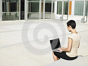 Businesswoman Using Laptop Outside Office