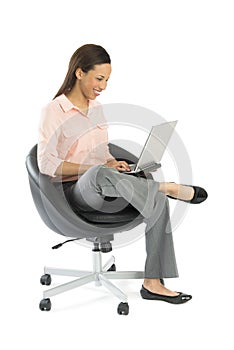 Businesswoman Using Laptop While Sitting On Office Chair