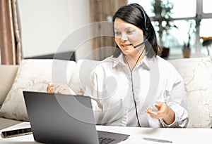 Businesswoman using laptop talk to colleagues in video call while smart working from home at living room. working at home remotely
