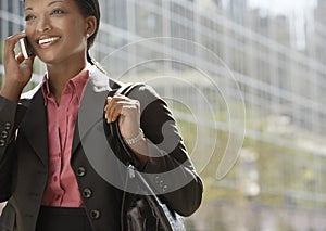 Businesswoman Using Mobile Phone Against Building