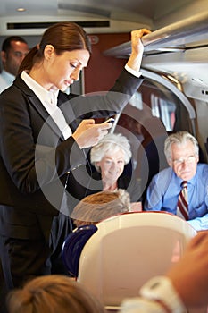 Businesswoman Using Mobile Phone On Busy Commuter Train