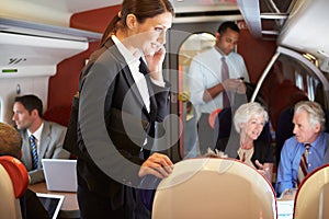 Businesswoman Using Mobile Phone On Busy Commuter Train