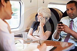 Businesswoman Using Mobile Phone On Busy Commuter Train photo