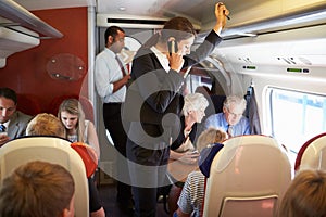 Businesswoman Using Mobile Phone On Busy Commuter Train photo