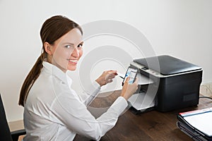 Businesswoman Using Mobile Phone For Printing Graph