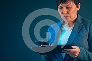 Businesswoman using mobile phone and tablet computer