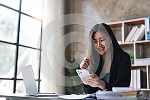 Businesswoman using mobile phone at work, chatting or social network concept