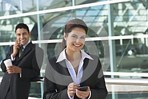 Businesswoman Using PDA Outside Office