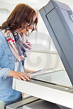 Businesswoman using photocopier in creative office