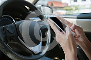 Businesswoman using smart phone mobile phone in car while careless driving.