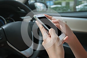 Businesswoman using smart phone mobile phone in car while careless driving.