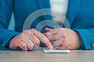 Businesswoman using smartphone, close up of hands