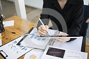 Businesswoman using stylus pen and writing information on digital tablet.