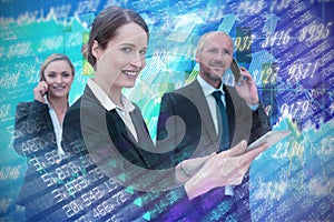 Composite image of businesswoman using tablet while colleagues talking on phone in background