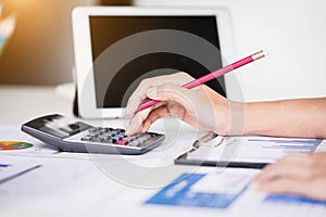 Businesswoman using tablet computer and calculator for calculating financial documents. Accounting,Finances and economy concept.