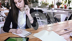 Businesswoman using tablet computer with green touch screen in cafe