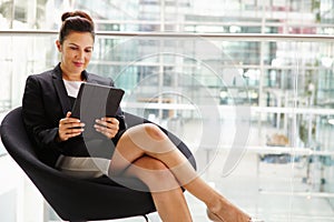 Businesswoman using tablet computer, three quarter length photo