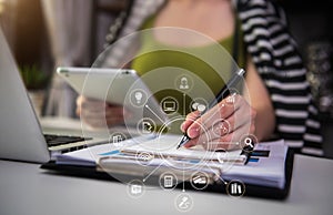 Businesswoman using tablet with laptop and document on desk in modern office .