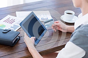 Businesswoman using tablet pc and holding credit card