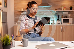 Businesswoman using tablet pc in home kitchen