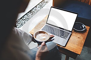 A businesswoman using and touching on laptop touchpad with blank white desktop screen in cafe