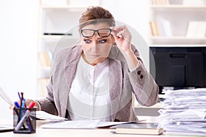 The businesswoman very busy with ongoing paperwork