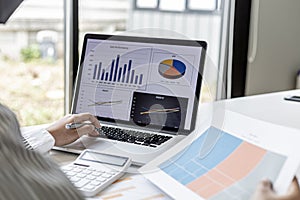 Businesswoman viewing financial data on laptop, she is reviewing financial data to bring to meetings with business partners.