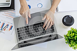 Businesswoman viewing financial data on laptop, she is reviewing financial data to bring to meetings with business partners.