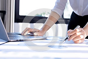 Businesswoman viewing financial data on laptop, she is reviewing financial data to bring to meetings with business partners.