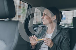 Businesswoman waiting at car back seat