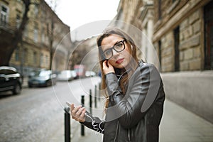 Businesswoman walking down the street while talking on smart phone