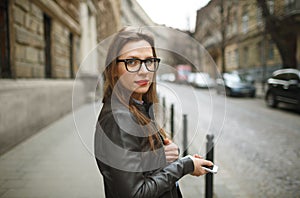 Businesswoman walking down the street while talking on smart phone