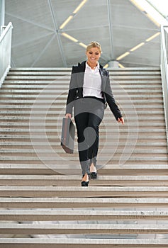 Businesswoman walking downstairs with briefcase