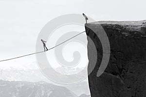 Businesswoman walking on the rope over the gap