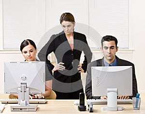 Businesswoman watching co-workers work