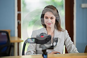 Businesswoman wear headset Live Code podcast and recording talking with camera. online broadcast interview speaker social media.