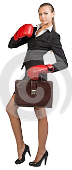 Businesswoman wearing boxing gloves holding