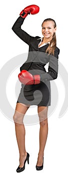 Businesswoman wearing boxing gloves standing with