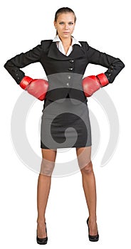 Businesswoman wearing boxing gloves standing