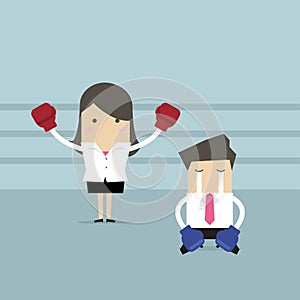 Businesswoman wearing boxing gloves standing in boxing ring as winner and defeated opponent kneel on floor.