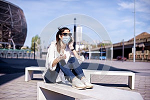 Businesswoman wearing face mask and plastic glowes while on the street during pandemic in the city