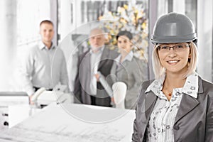 Businesswoman wearing hardhat in office