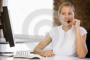 Businesswoman wearing headset in office smiling