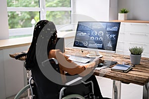 Businesswoman On Wheelchair Analyzing Graph