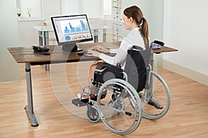 Businesswoman On Wheelchair Analyzing Graph