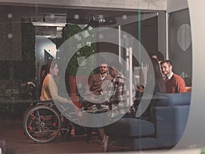 Businesswoman in wheelchair having business meeting with team at modern office